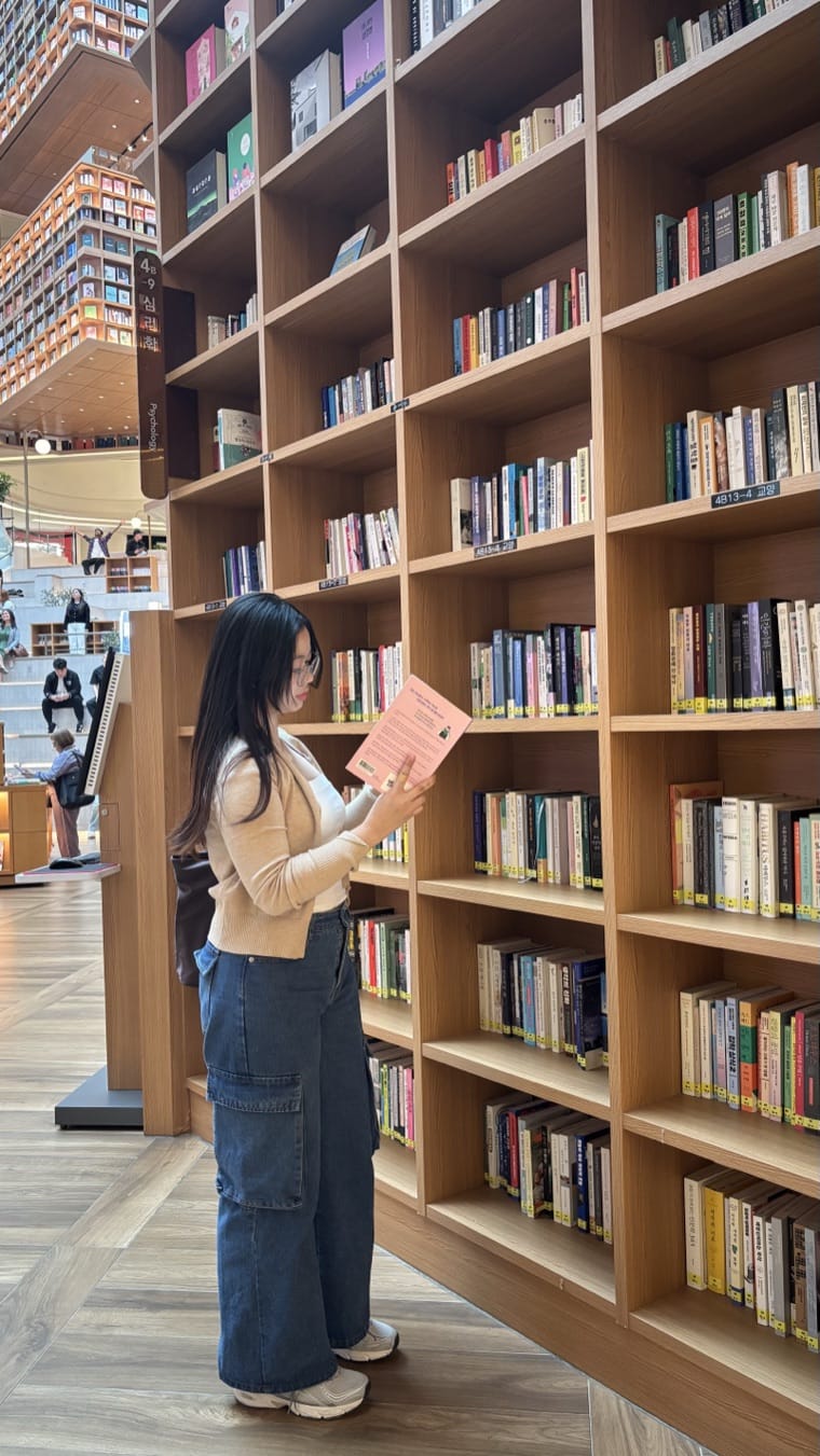 Rhema browsing a library bookshelf